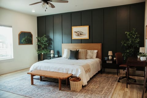 Primary bedroom with king bed, luxury linens and a desk