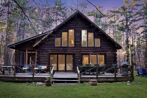 Surrounded by nature, the cabin’s backyard offers a private deck, dining area, and serene views through the windows.