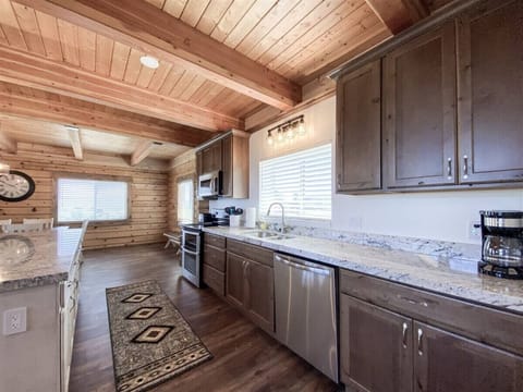 Beautiful log cabin kitchen with modern appliances, perfect for cooking and gathering with family.