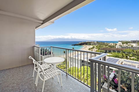 Stunning coastal views stretch across turquoise waters and sandy shores from this private balcony, where island mountains meet endless ocean horizons.