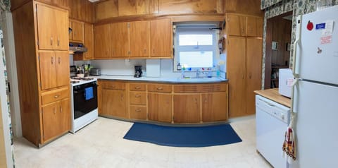 Fully stocked kitchen with microwave, dishwasher, and full-size refrigerator.