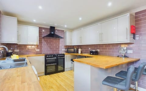 A bright, modern kitchen fully equipped for self-catering, featuring a breakfast bar for casual holiday meals.