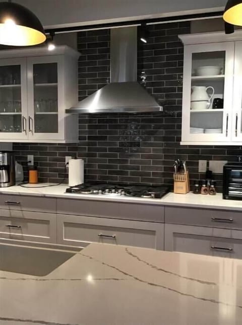 Kitchen with quartz countertops, and 10’ island, wine cooler and farm sink.