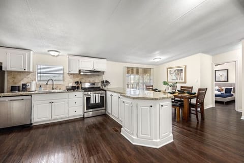 Fully stocked kitchen with granite counters, island seating, and modern appliances