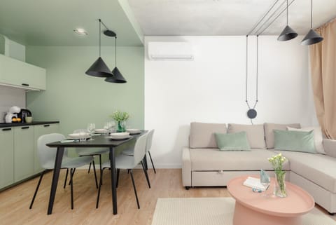 A modern living room with a comfortable sofa, a TV, and a wooden coffee table, arranged in a minimalist style.