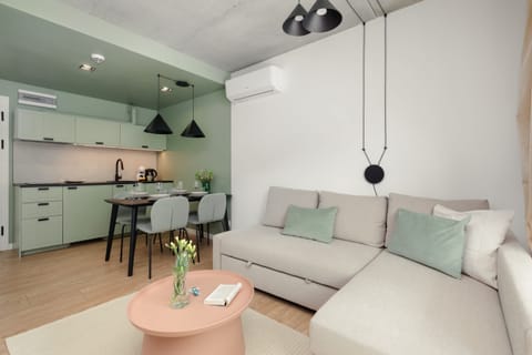 A modern living room with a comfortable sofa, a TV, and a wooden coffee table, arranged in a minimalist style.