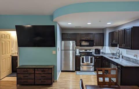 65 Inch Smart TV and Kitchen Area