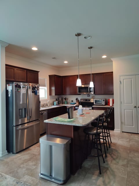 kitchen with appliances and island with 3 chairs 