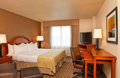 Unwind in a crisp king bed with warm lighting.