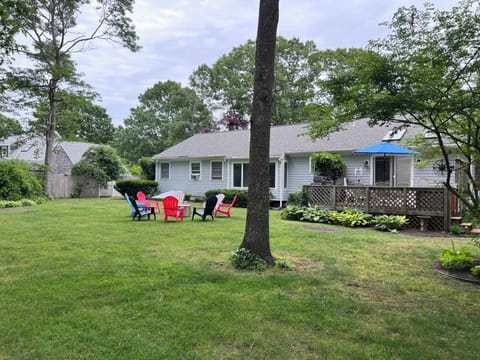View of backyard including Adirondack chairs, and fire pit.