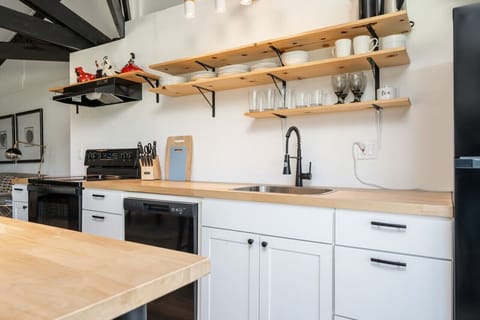 Modern kitchen with open shelving, butcher block counters, and everything you need for cooking at home.