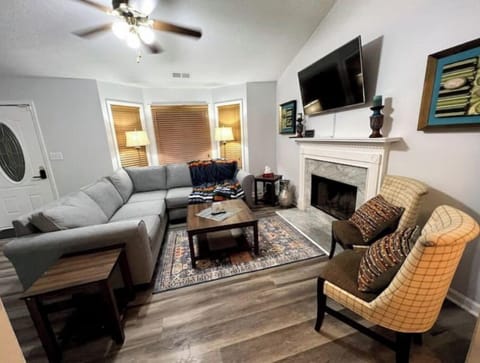 Living room with a cozy sectional sofa, smart TV, two chairs