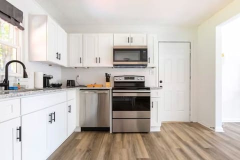 Sleek Contemporary Kitchen: Fully equipped with a coffee maker, oven, stove, microwave, and more for your culinary needs.