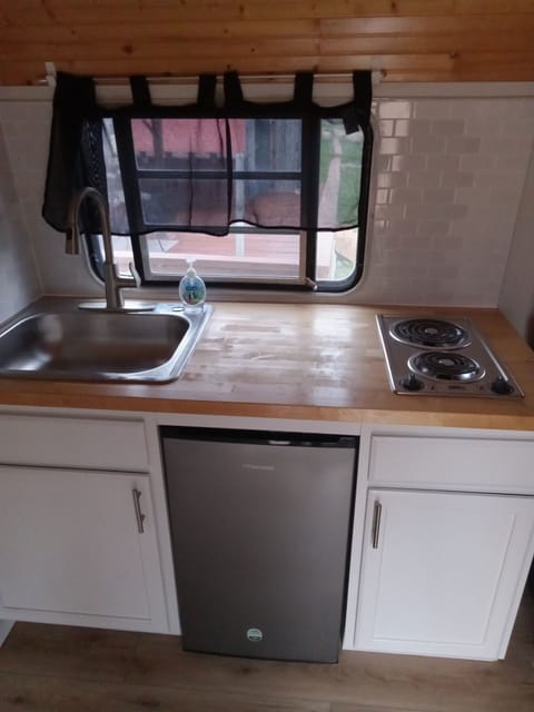 Cooking area with small fridge. 