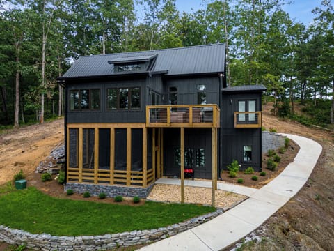 View of the home that faces the lake. Lower level screened in porch. Upper deck.