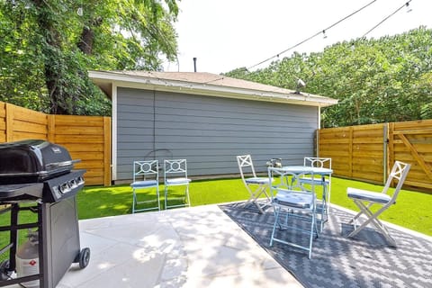 Spacious backyard with patio seating and a grill. Perfect for outdoor dining or relaxing in a private setting.