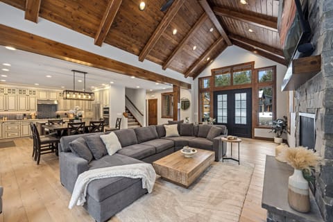 Rustic elegance, featuring a stone fireplace, comfy seating, and natural wood beams