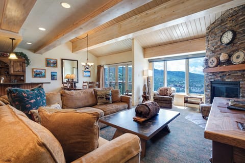Sink into plush sofas by the stone fireplace and soak in breathtaking mountain views through floor-to-ceiling windows in your rustic-chic retreat.
