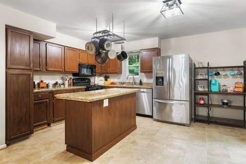 Open concept kitchen stocked with cookware, service for 12 and a coffee bar.