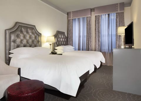 Unwind in crisp linens beneath elegant tufted headboards.