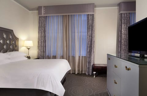 Wake gently to filtered daylight through layered, elegant drapes.