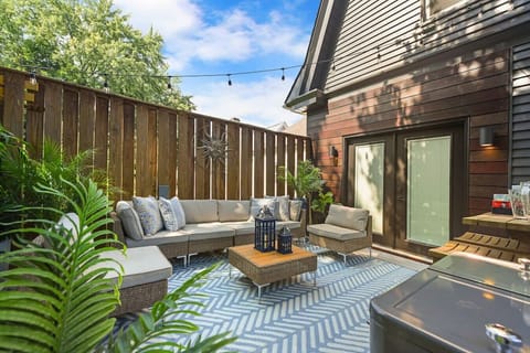 Private backyard oasis with seating, greenery, and string lights