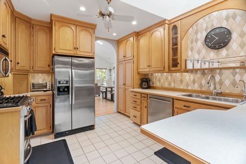 Your fully equipped kitchen features warm wood cabinetry, stainless steel appliances, and elegant tile backsplash for memorable cooking experiences.