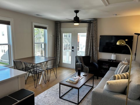 Living area with 4 person dining set, leather chair, TV with streaming services