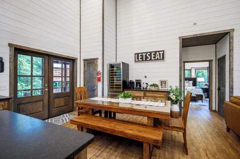 Wine fridge, mini fridge, and coffee car located next to the dining room table. 