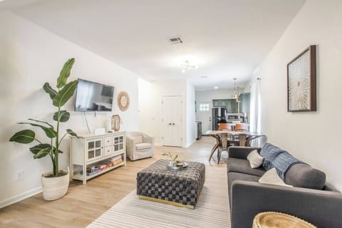 This modern, light-filled living room features stylish décor, cozy seating, a smart TV, and an open-concept design—perfect for relaxing with family or entertaining guests.