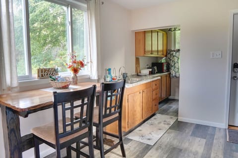 The kitchen features a counter-height live-edge table facing the picture window.