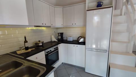 Inside kitchen with ceramic hob also showing stairs to mezzanine