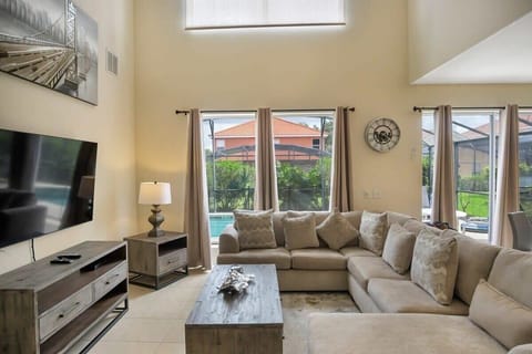 Relax in this spacious living room with a cozy sectional and stunning pool views, perfect for unwinding after a day of adventure.