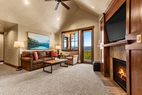 Bright living room with private balcony & fireplace.