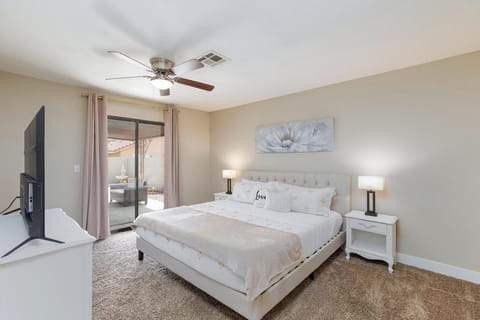 Primary bdr with blackout curtains, en suite bathroom, and access to backyard.