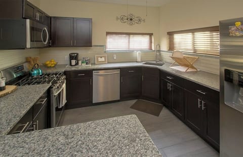 Remodeled kitchen with marble, steel surfaces, and modern appliances.
