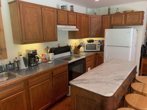 Kitchen includes a full-size stove, fridge, microwave, and 10-cup coffee maker.