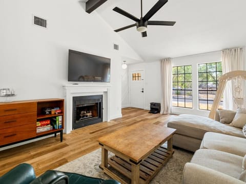 Relax in this stylish and spacious living room, featuring a cozy fireplace, ample seating, and natural light!