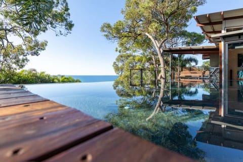 Infinity pool with ocean outlook, spacious deck, and outdoor seating. Ideal for couples or families seeking luxury.
