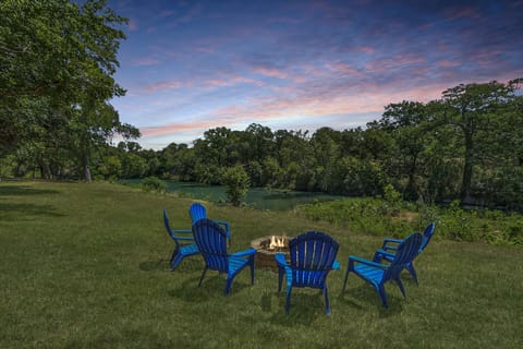Seating around a firepit overlooking the river at the back of the property