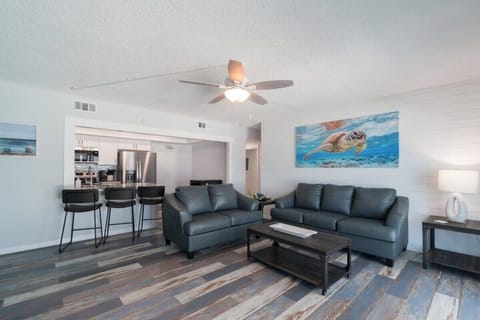 Modern living room with leather sofas and an open kitchen bar seating area