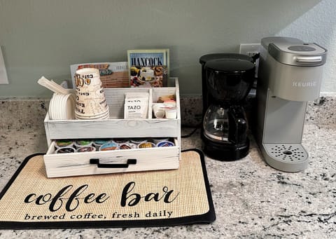 Drip and k-cup coffee makers with sample k-cups, tea, creamer, and sugars