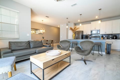 Step into this spacious, comfortable living area. The expansive room is adorned with tasteful decor, offering a blend of modern aesthetics and homey warmth. 