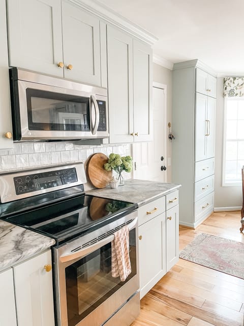 Modern kitchen with sleek appliances, marble counters, and a bright, inviting design.
