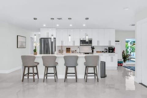 The dining area features a 6-person dining table perfect for your group feasts. There are 4 additional counter stools at the impressive quartz waterfall island.