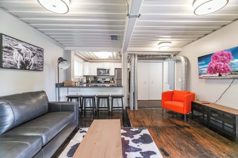 View of kitchen from living area.  Note 55"smart TV on the right over a console that contains games and cards for your leisure.
