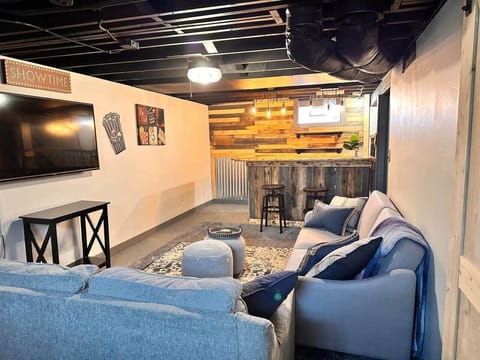 Finished basement with sofa's and bar area with TV and game table