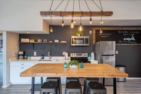 Fully stocked kitchen + woodsy dining space for home-cooked meals.