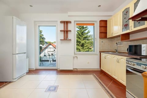Bright kitchen angle displaying easy access to the outdoor area and plentiful storage, making meal prep a breeze.

