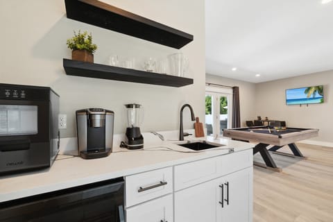 First-floor half kitchen / wet bar area — perfect for poolside snacks, drinks, and added entertaining space.